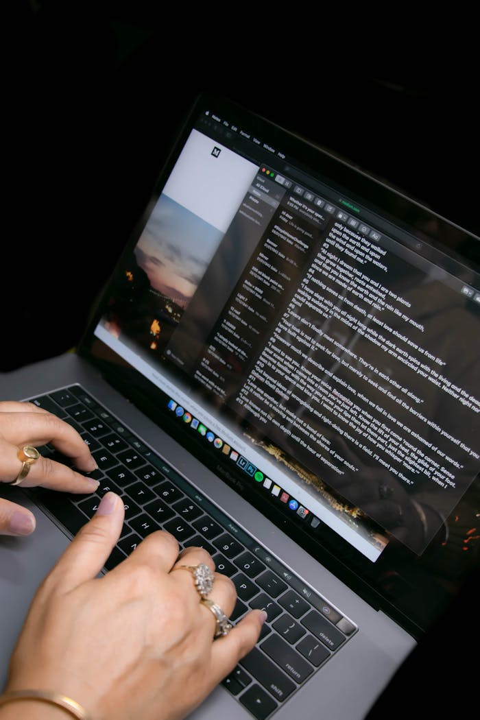 Close-up of hands typing on a laptop with an email application open, showcasing digital communication.